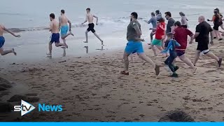 Hundreds of Scots brave the cold for Loony Dook dips [upl. by Enaled]