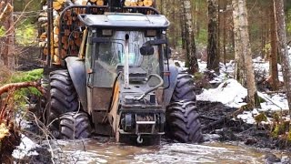 Valtra forestry tractor with big fully loaded trailer in wet snowy forest [upl. by Breban]