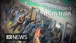 Faith in humanity restored as crowd lift train to save trapped man 2014  ABC News [upl. by Leacock]